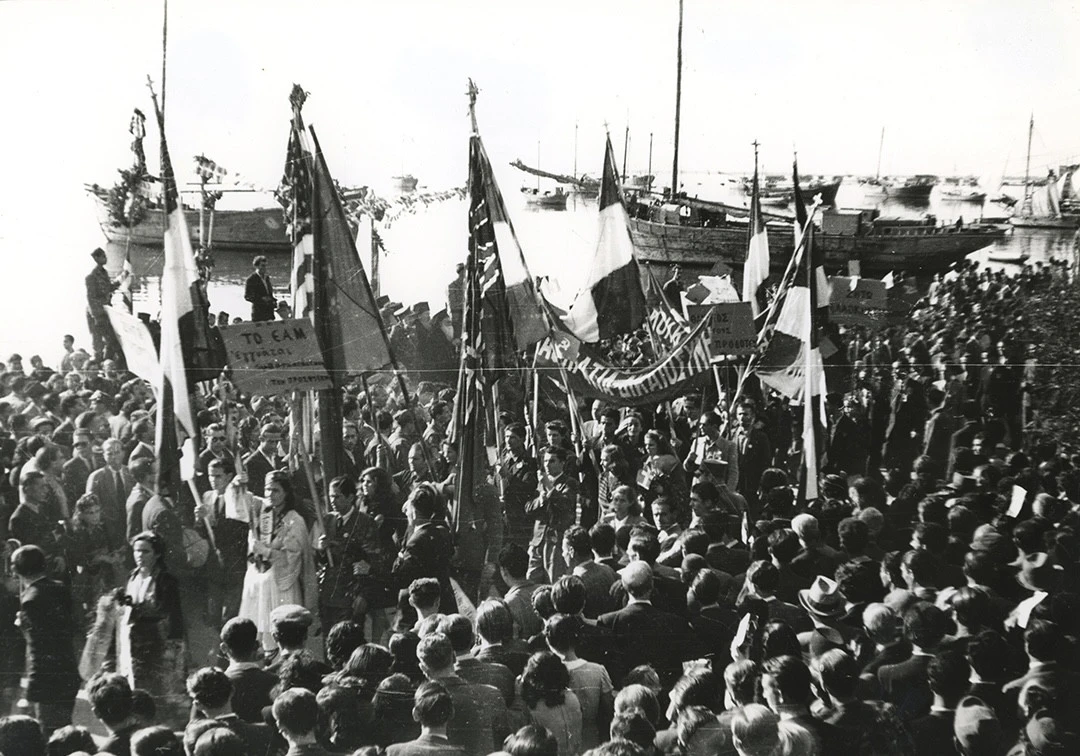 Η πορεία κατευθύνεται προς τον Λευκό Πύργο. Σημαίες ελληνικές, αγγλικές και αμερικάνικες, μαζί με πλεκτά του ΕΑΣ για δικαιοσύνη, δημοκρατία και λαοκρατία. Πηγή: Μουσείο Φωτογραφίας «Χρήστος Καλεμκερής» Δήμου Καλαμαριάς