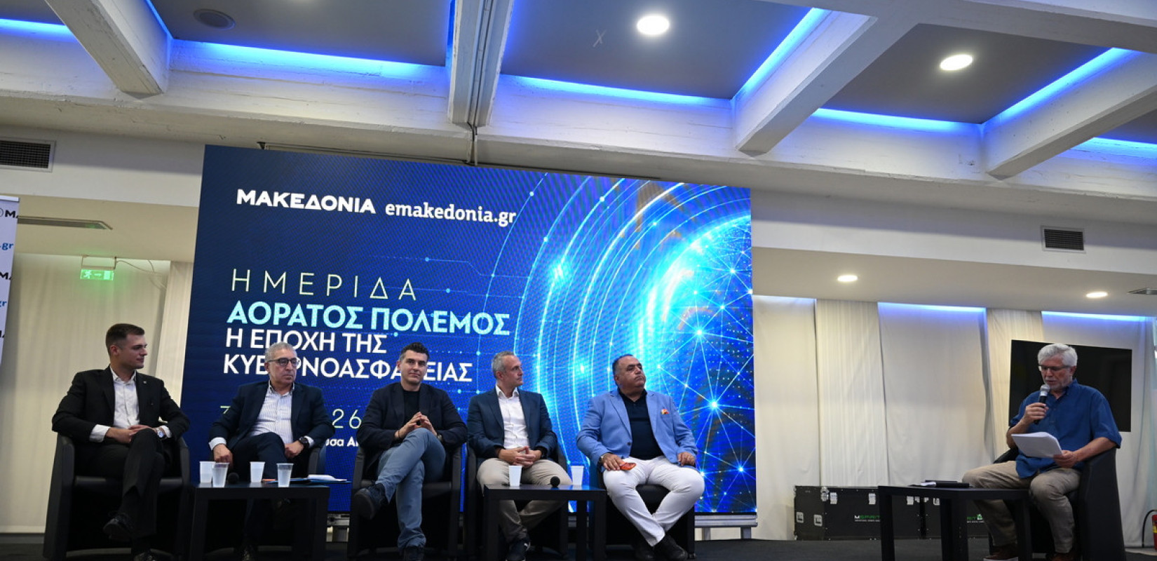 Οι ομιλητές της ενότητας με τίτλο «Ψηφιακή θωράκιση, Τεχνητή Νοημοσύνη και κρίσιμες υποδομές: Η νέα ασπίδα, από το κράτος έως και τις μικρές επιχειρήσεις» και ο δημοσιογράφος που έκανε τον συντονισμό, Νίκος Ηλιάδης. Φωτ. Δημήτρης Τασκούδης